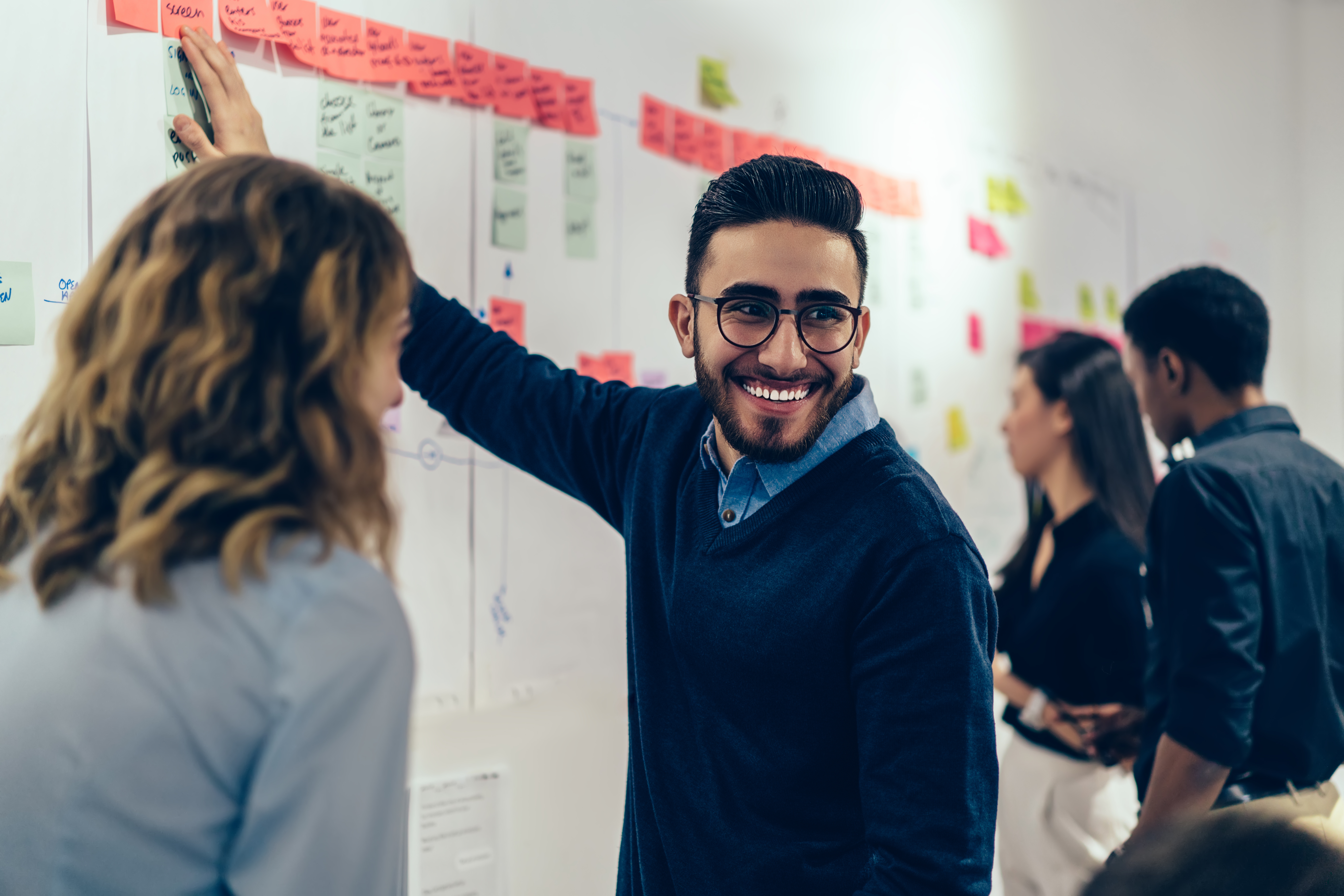 man smiling while collaborating with colleagues