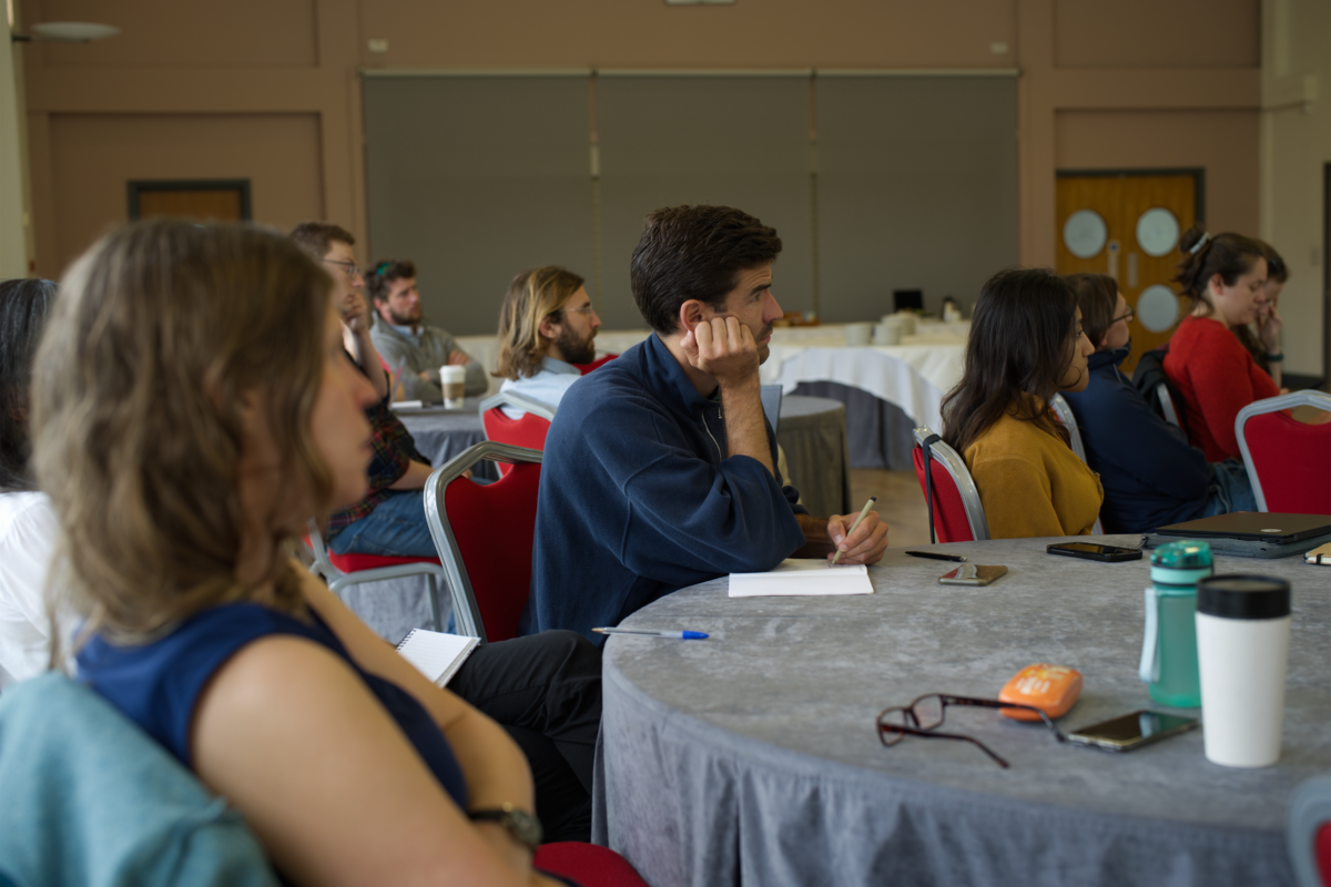 People sitting at tables listening to a talk.